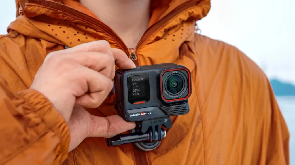 Оператор в оранжевой куртке с камерой Insta360 Ace Pro 2 на быстросъемном магнитном креплении